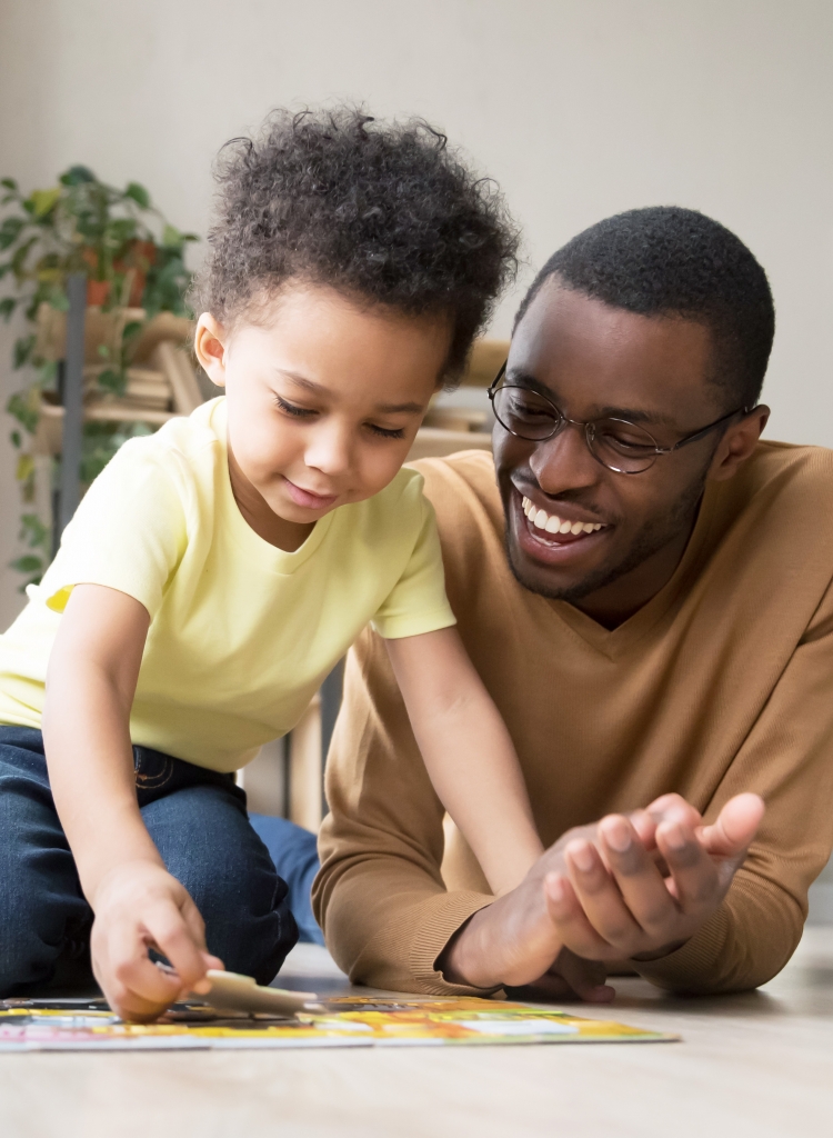African father and little son collect jigsaw puzzle at home Lakeland