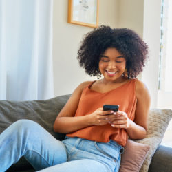 woman on couch using telehealth