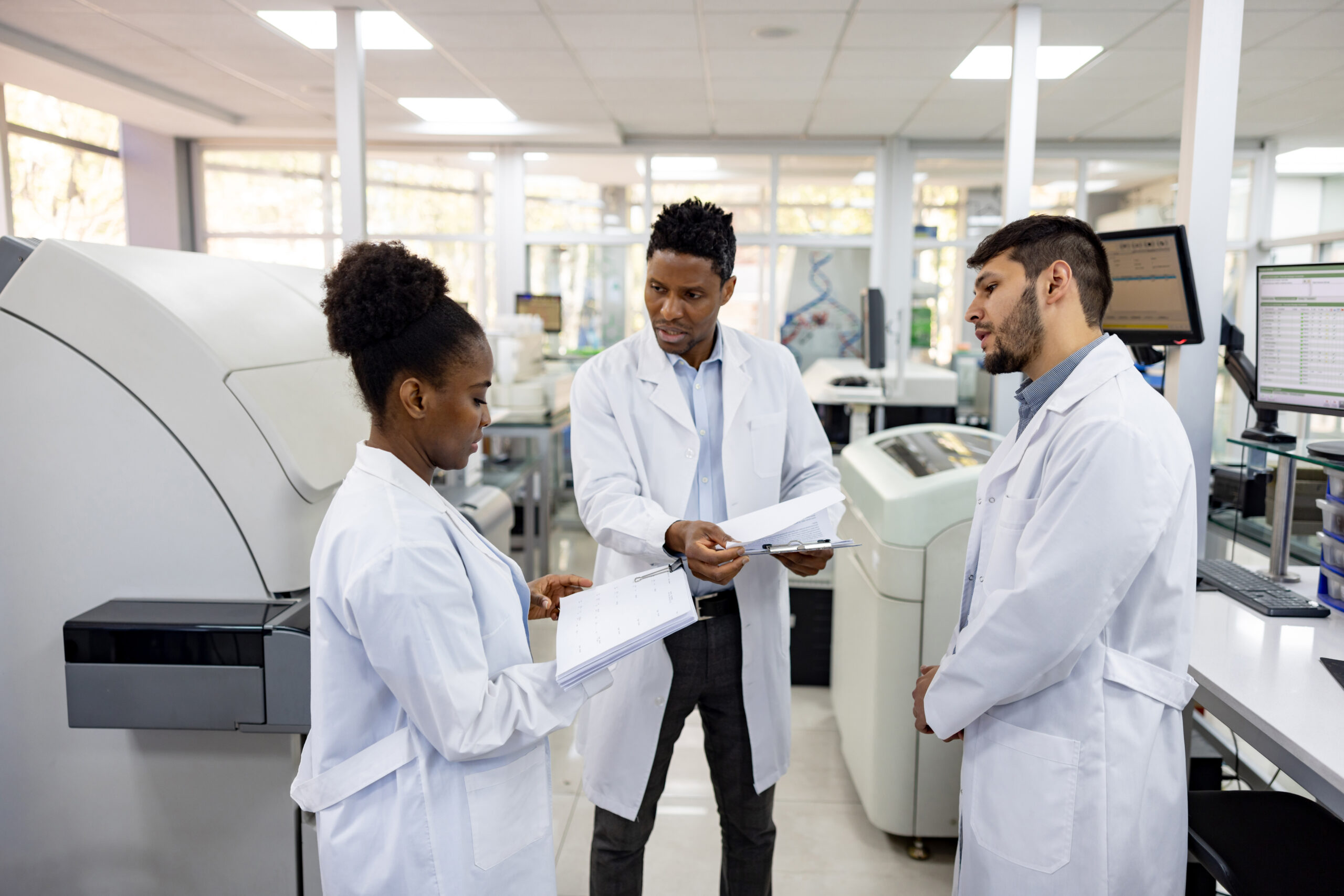 Group of doctors working at the laboratory discussing some test results ...