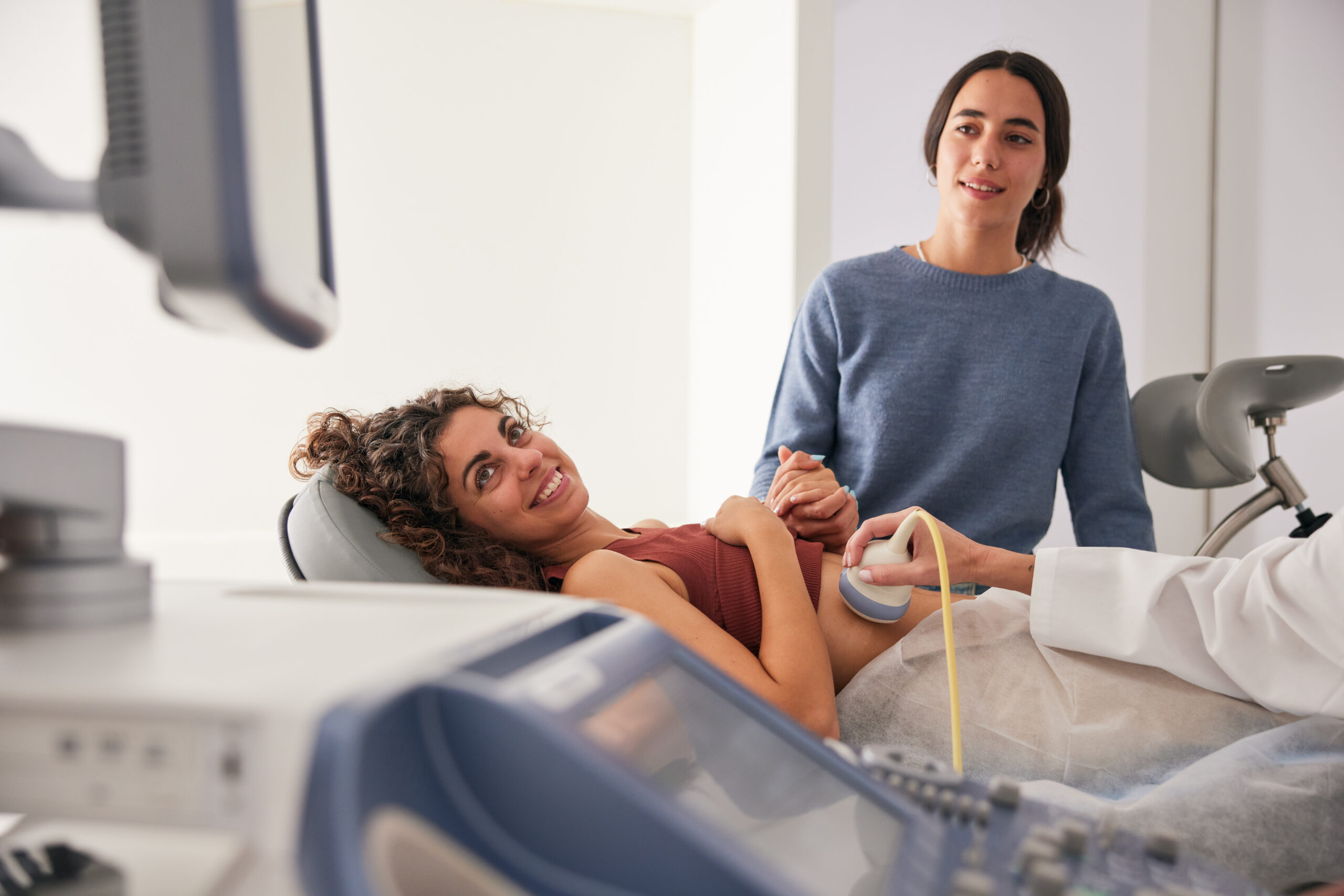 the-young-mother-and-her-wife-watch-the-ultrasound-screen-with-hopeful